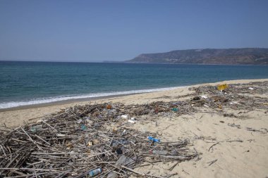 Kumsalda kirlilik. Plastik çöp, köpük, odun ve kirli atık yaz günü plajda..