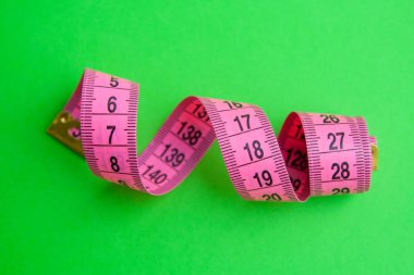 Renkli arkaplanda pembe santimetre ölçü bandı