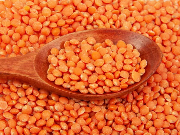 Red lentil in wooden spoon natural dry seed