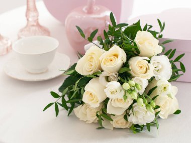 Parlak masanın üzerinde bir buket beyaz gül.