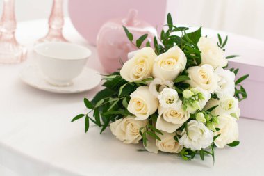 Parlak masanın üzerinde bir buket beyaz gül.