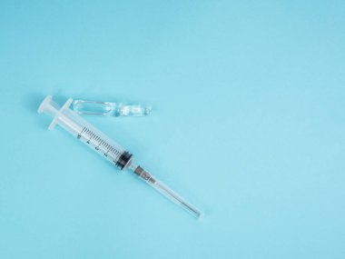 Mavi arkaplanda şırınga ve ampul