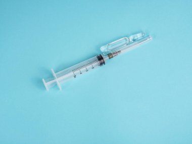 Mavi arkaplanda şırınga ve ampul