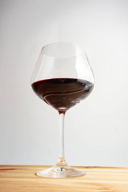 Kaliteli ahşap arka planda kırmızı şarap kadehi.
