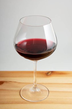 Kaliteli ahşap arka planda kırmızı şarap kadehi.