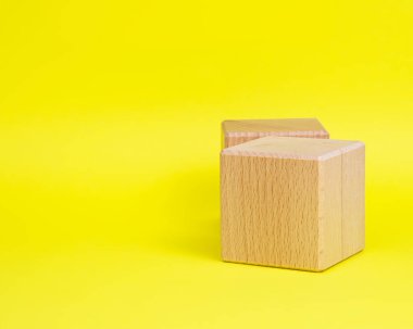 Sarı arkaplan kopyalama uzayında iki tahta küp kare