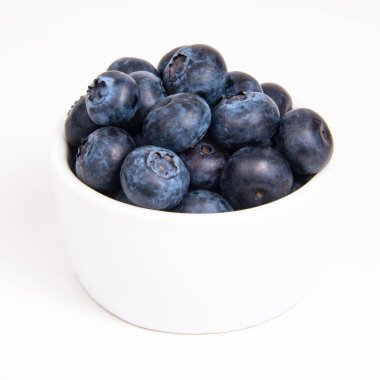 Beyaz arka planda beyaz tabakta taze yaban mersini