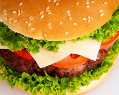 Beyaz arka planda izole edilmiş peynirli lezzetli bir hamburger.