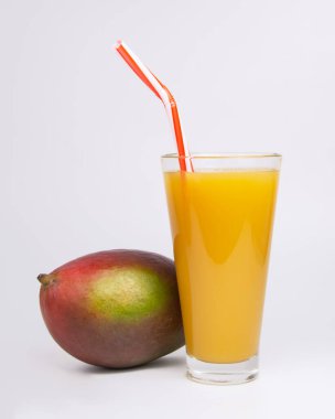 Tropikal mango egzotik meyvesi ve beyaz bardakta meyve suyu.