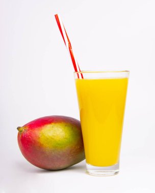 Tropikal mango egzotik meyvesi ve beyaz bardakta meyve suyu.