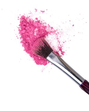 Ezilmiş pembe allık göz makyajı ve makyaj fırçası beyaz arka planda izole edilmiş.