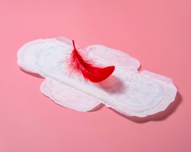Pembe arka planda duran kırmızı tüylü hijyenik peçete.