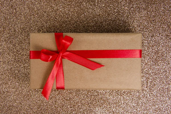 Ремесленная Подарочная Коробка Красным Бантом Блестящем Фоне — стоковое фото