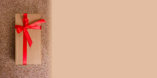 光沢のある背景に赤い弓とクラフトギフトボックス — ストック写真