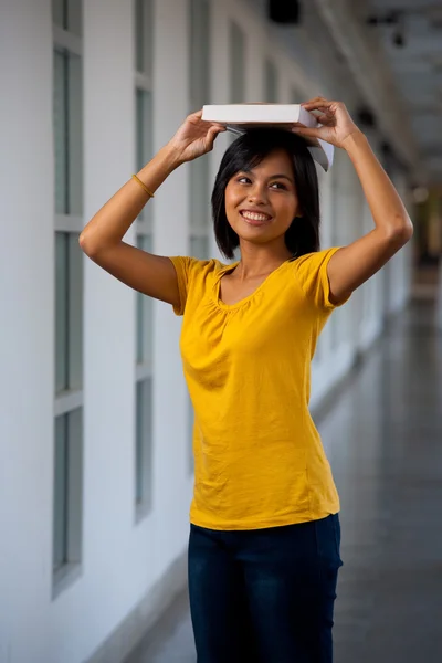 Playful Asian Student Balancing Book Head — Stockfoto