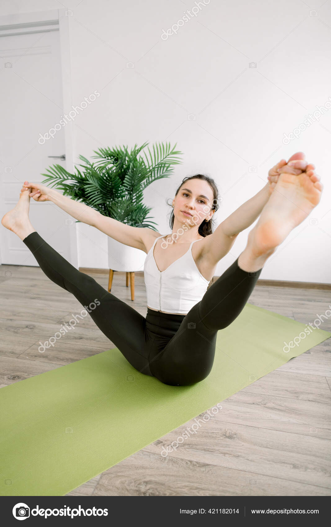 Mujer bonita vistiendo ropa deportiva y haciendo yoga.