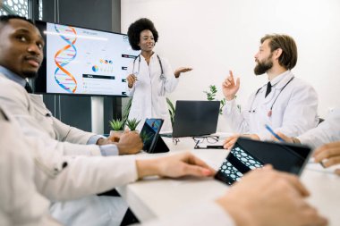 Araştırma ve test kavramı, tıp, genetik. Kromozom hastalıklarını ya da beyaz erkek arkadaşıyla buluşup DNA testini tartışan oldukça genç odaklı Afrikalı kadın bilim adamı.