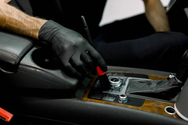 Cortado de perto imagem da mão do trabalhador de serviço de carro masculino na luva de borracha, limpeza de poeira do interior do carro de luxo, usando escova macia especial. Limpeza do carro e detalhando conceito, lavagem a seco — Fotografia de Stock