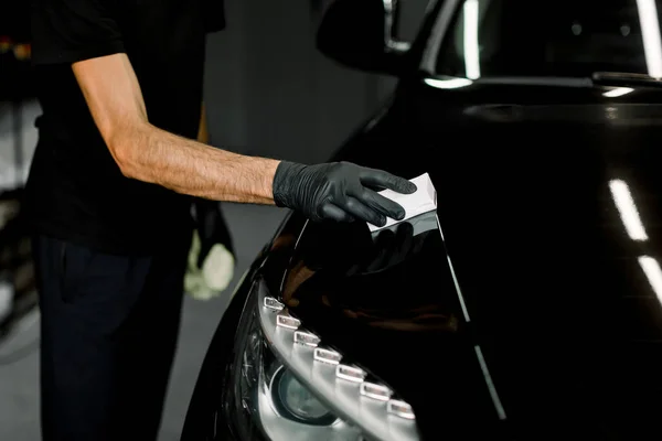 Protection the car body from scratches, chips and damage. Cropped close up shot of process of applying a nano-ceramic coating on the cars hood by a male worker with a sponge and special composition — Stock Photo, Image