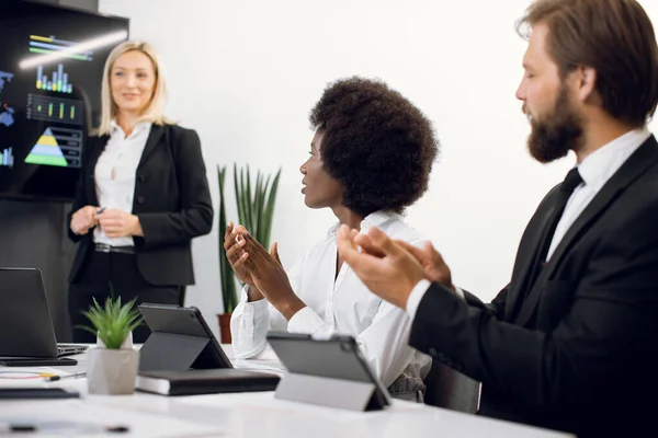 Gros plan des travailleurs corporatifs satisfaits heureux, hommes blancs et femmes d'affaires africaines, applaudissements mains après le discours professionnel de son patron blond femme. Focus sur dame noire — Photo