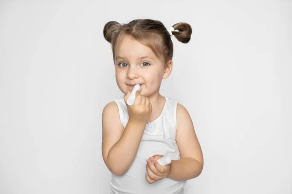 Cuidado de los labios, cosméticos para niños. Adorable linda niña de 3 años aplicando bálsamo labial en sus labios. Belleza, cuidado, hidratación y nutrición con vitaminas y aceite. Aislado sobre fondo blanco — Foto de Stock