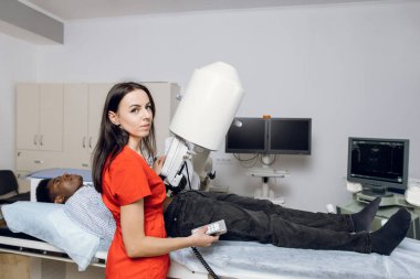 Extracorporeal şok dalgası litotripsi. Taş tedavisi için zararsız bir prosedür. Genç profesyonel doktor, taşların ultrason tespiti için modern lithotriptor kullanıyor.