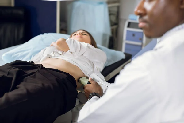 Terapia de ondas de choque extracorpóreas em urologia. Tiro cortado de paciente deitado, tendo diagnósticos de ultra-som para determinar a posição pedras nos rins antes do procedimento de litotripsia. — Fotografia de Stock