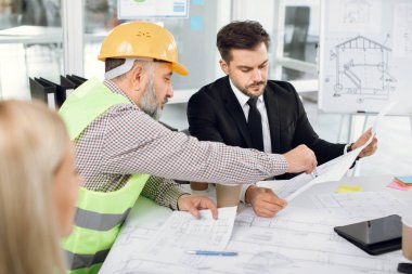 Mühendisler ve mimarlar yeni bina planını tartışıyor