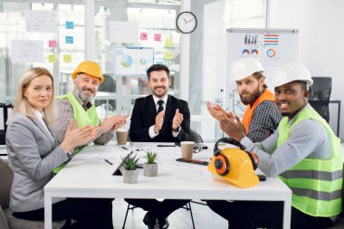 İnşaat ekibi başarılı bir toplantıdan sonra el çırpıyor