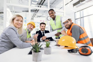 Mimarlar, tasarımcılar ve mühendisler toplantı yapıyorlar.