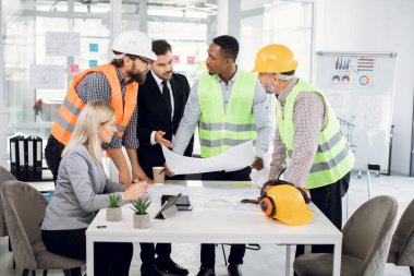 Ayrıntılı planlar üzerinde çalışan çeşitli uzmanlar