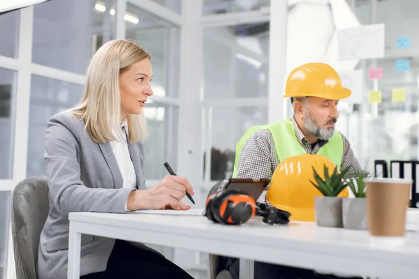 Gruppe af mennesker diskuterer byggeprojekt indendørs - Stock-foto