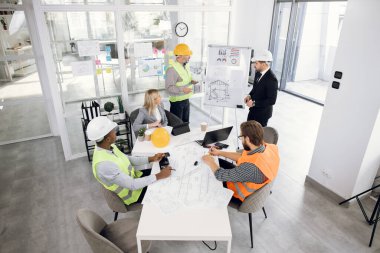 Çok ırklı insanlar inşaat fikirlerini tartışıyor