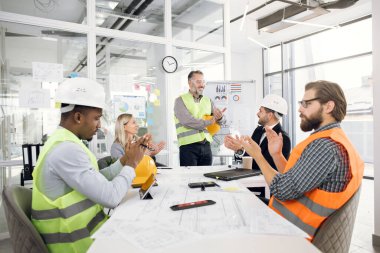 İnşaat ekibi projenin sunumu sırasında alkışlıyor