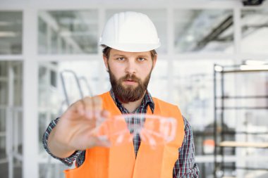 Kamerada koruyucu gözlük takan sakallı bir sanatçı.