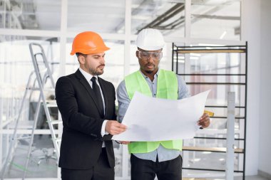 İnşaat sürecini kontrol eden çok ırklı adamlar