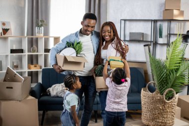 İki kız çocuğu taşınmak için ailelerin kutularını toplamalarına yardım ediyor.