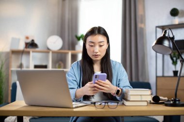 İş için akıllı telefon kullanan Asyalı kadın.