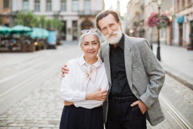 Mutlu yaşlı çift, sarılmak için şehir caddesinde