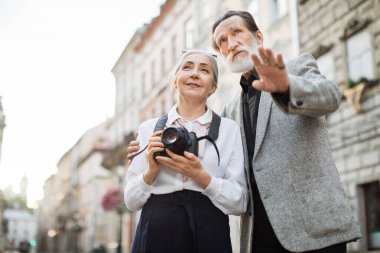 Kıdemli adam ve kadın dışarıda kucaklaşıyorlar.