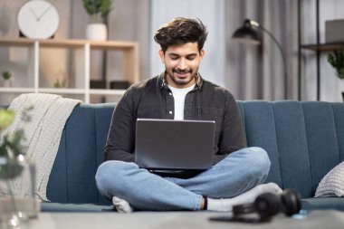 Genç, yakışıklı Hintli ya da Arap bir adam futbol maçı ya da ilginç bir film izliyor, evdeki kanepede dizüstü bilgisayarla oturuyor. Akşamları evde boş vakit geçiririz.