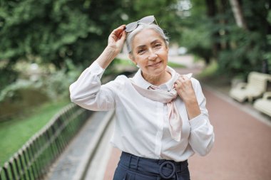 Gülümseyen kadın emekliler Green Park 'ta boş vakitlerini geçiriyorlar.