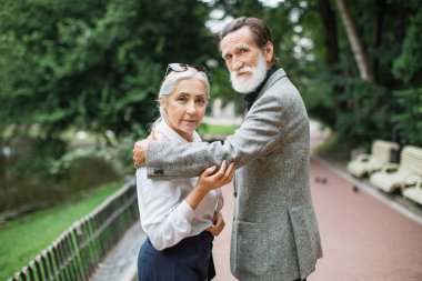 Yeşil Park 'ta birlikte poz veren büyüleyici yaşlı çift.