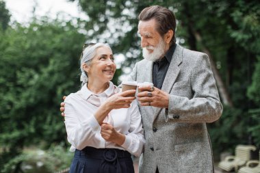 Mutlu, olgun bir çift kahve içip sarılıyorlar.