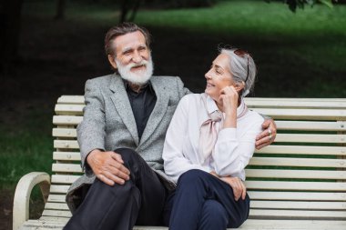 Green Park 'taki ahşap bankta oturan romantik yaşlı çift.