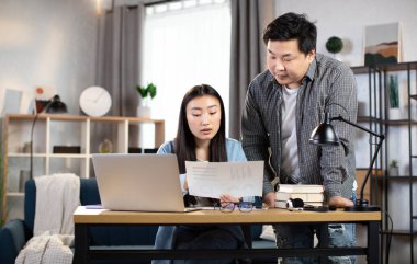 İki Asyalı iş ortağı ofiste iş görüşmesi yapıyor.