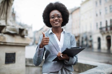 Gülümseyen Afrikalı iş kadını başparmağını gösteriyor.