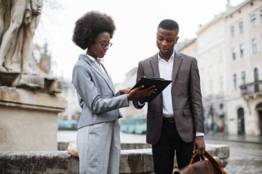 İki meşgul Afrikalı sokakta panoya bakıyor.