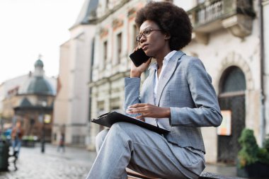 İş kadını cep telefonu konuşması sırasında panoya not alıyor