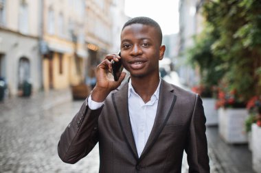 Kendine güvenen afro iş adamı cep telefonuyla konuşuyor.